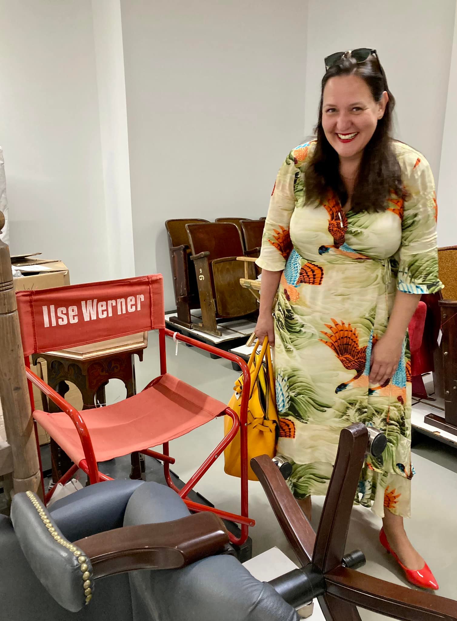 Ministerin Manja Schüle steht vor einem Stuhl der den Namen der Schauspielerin Ilse Werner trägt