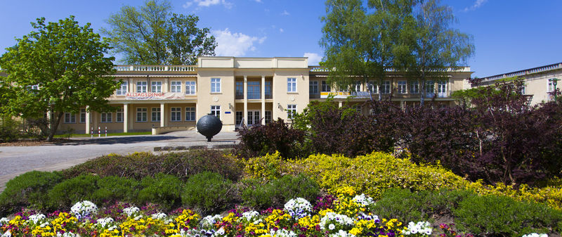Gezeigt wird auf dem Foto das Haus von außen mit Blumenbeet im Vordergrund