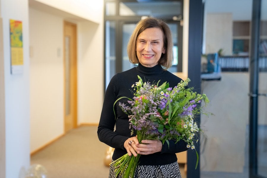 Gezeigt wird Prof. Grande mit einem Blumenstrauß