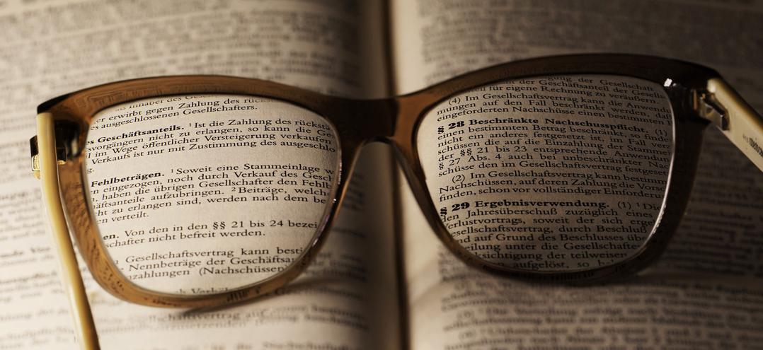 eine Brille liegt auf einem Gesetzbuch