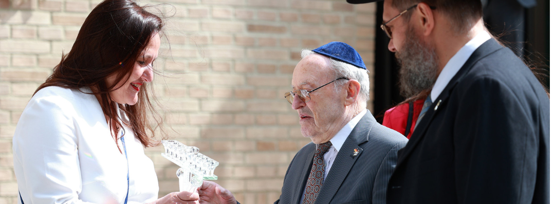Bild: Foto zeigt Ministerin bei Übergabe der Menora anlässlich der Synagogeneröffnung 2024