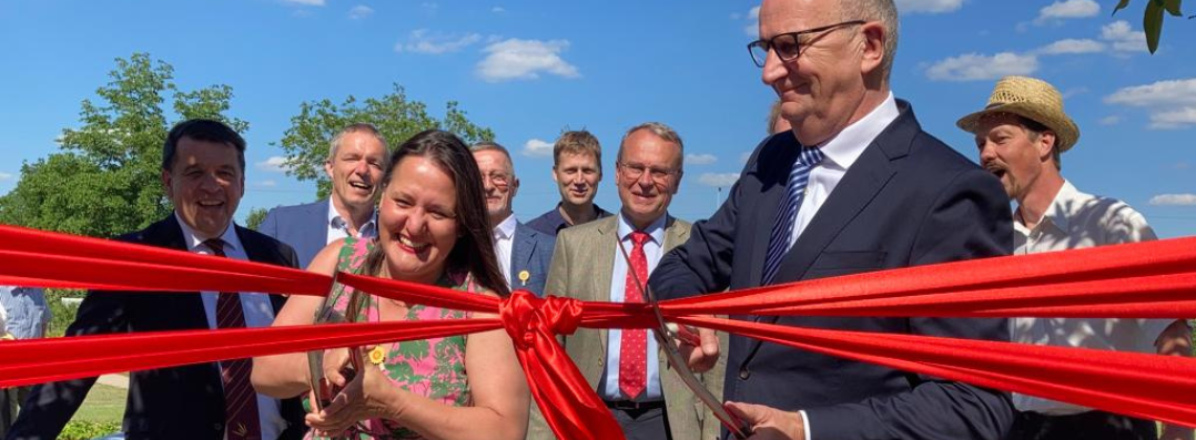 Bild: Zu sehen sind Ministerin Schüle und Ministerpräsident Woidke, die symbolisch ein rotes Band durchschneiden