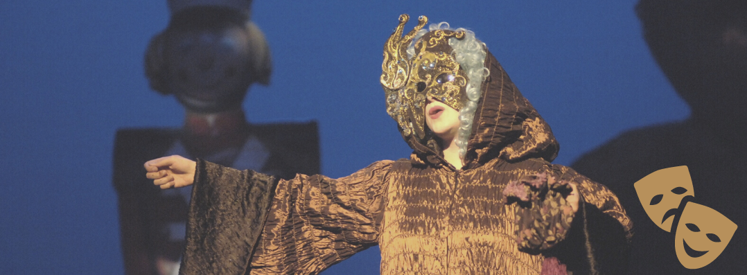 Bild: Zu sehen ist eine Schauspielerin verkleidet mit einer goldenen Gesichtsmaske bei einer Aufführung